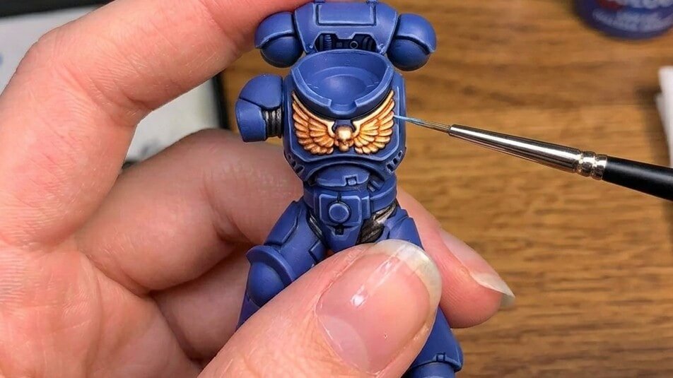 Wargaming figure painting edge highlighting on a blue miniature