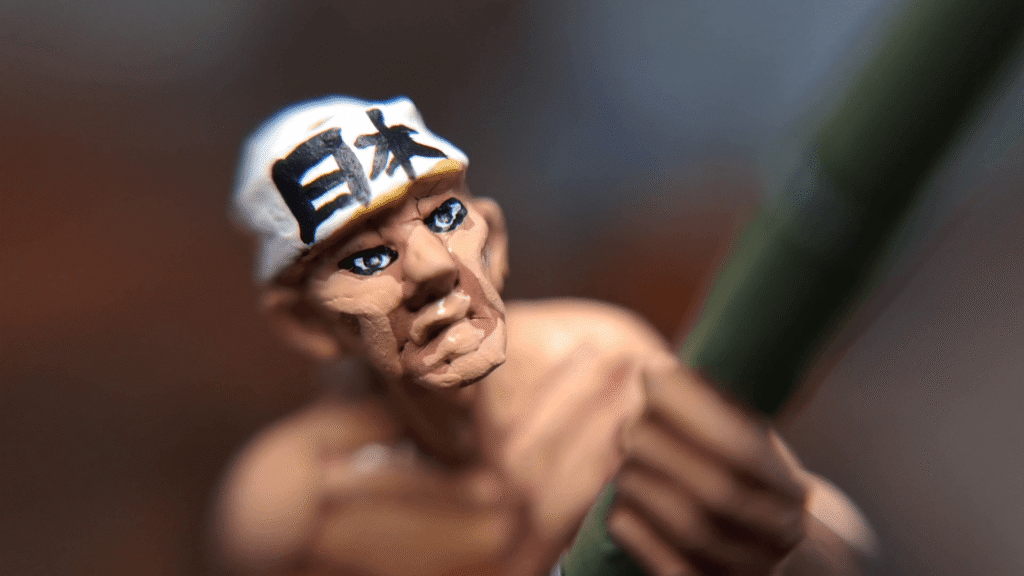 Close-up of a 28mm Japanese soldier miniature with subtly painted eyes, using simple dark dots and lines instead of exaggerated white eyeballs.