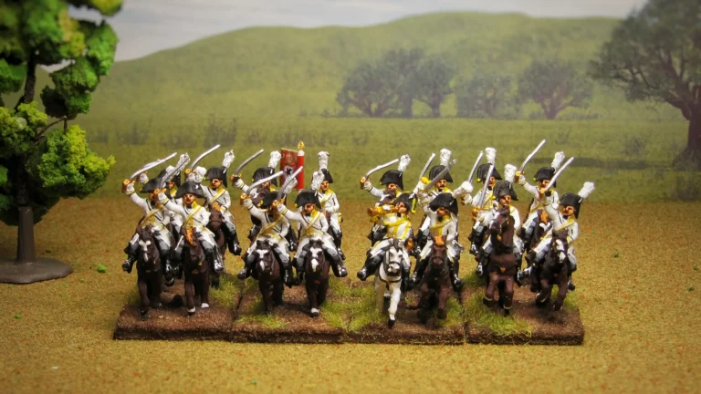 28mm painted Napoleonic Saxon Garde du Corps heavy cavalry miniatures charging on horseback with sabers raised in a detailed battlefield scene with hills
