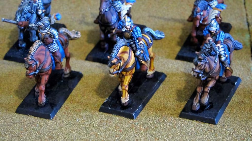 Three painted cavalry horses in different coat colors