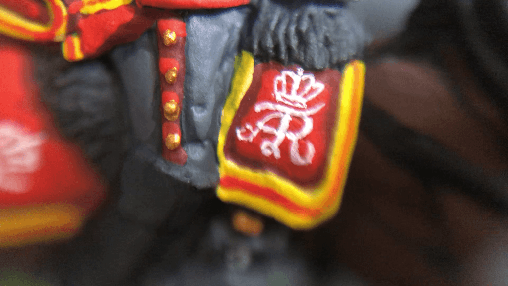 Close-up of hand-painted heraldic details on a cavalry saddlecloth
